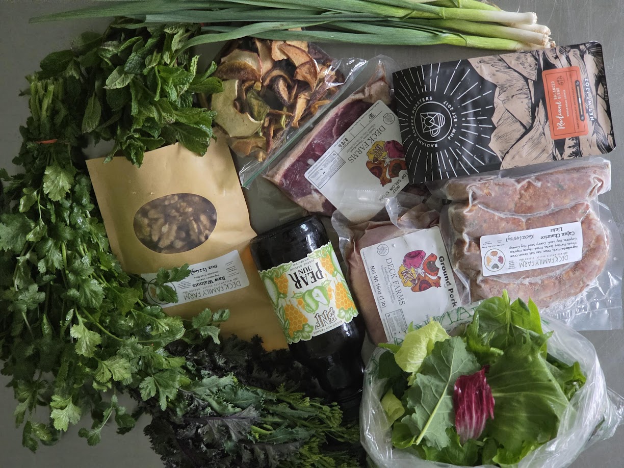 Deck Family Farm meats, pantry goods, and produce arranged together.